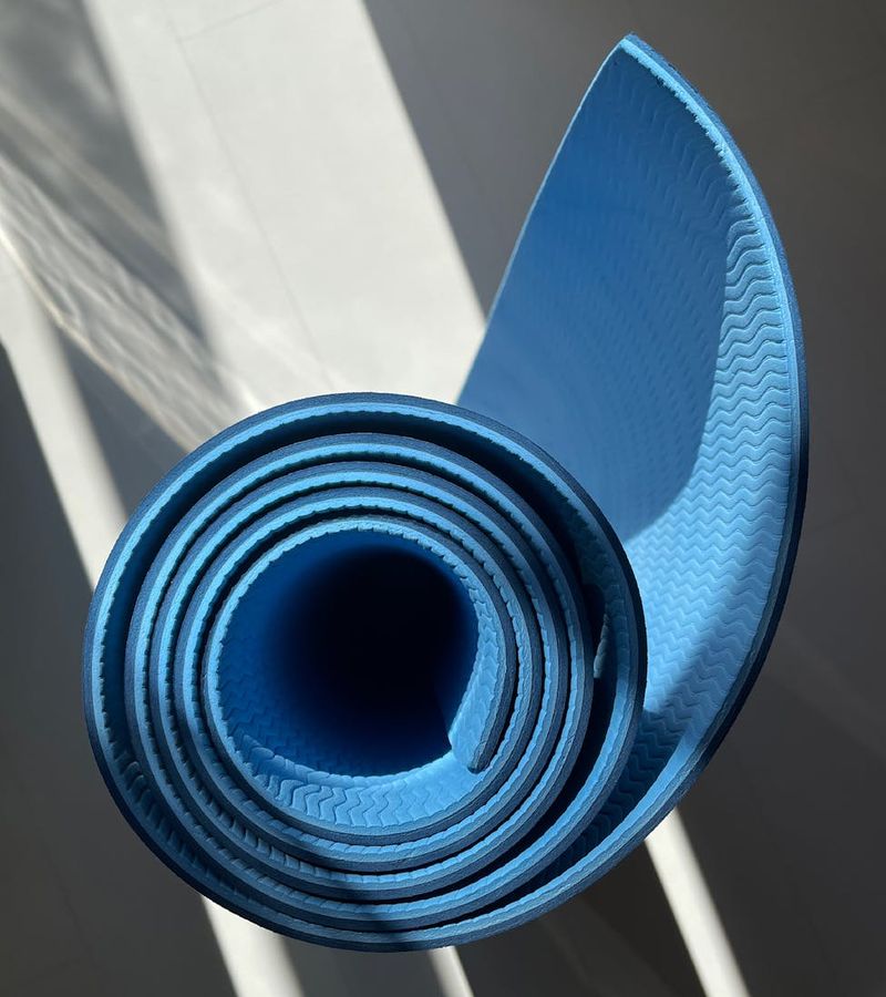 A simple, clean home space with a yoga mat ready for a workout.