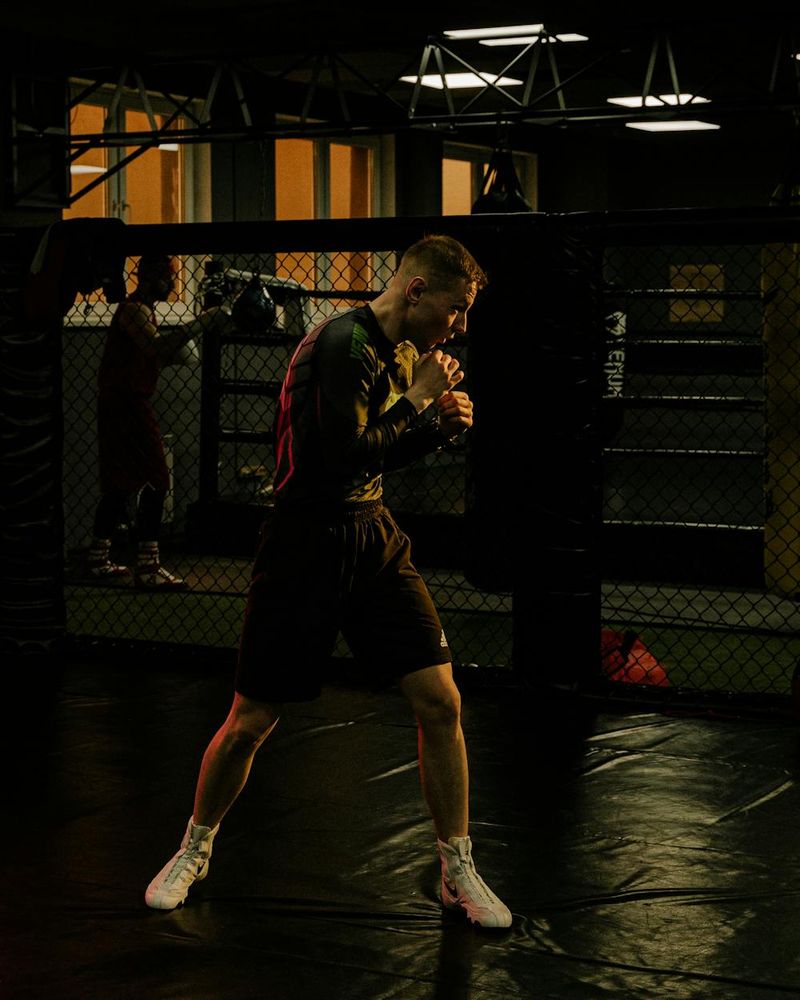 Man performing a bodyweight exercise in a dark, focused environment.